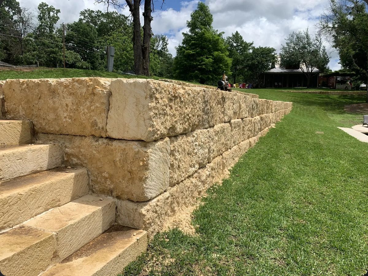 Cream limestone block wall and steps in a backyard